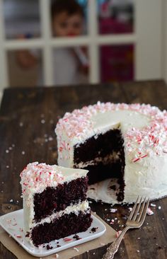 a piece of cake with white frosting and sprinkles on a plate