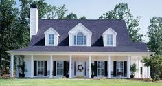 a white house with black shutters and wreath on the front door