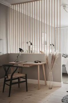 a bedroom with white walls and wooden slats on the wall, along with a desk