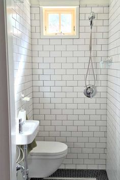 a white toilet sitting next to a sink in a bathroom under a window with a skylight