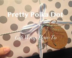 a person holding a wrapped present with polka dot wrapping paper on it and the words pretty polka dot gift wrap tour - to