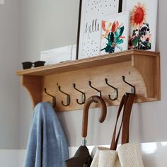 a coat rack with umbrellas hanging from it's hooks and two purses