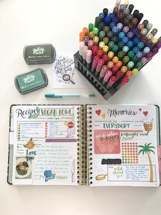 an open planner with markers and pens next to it