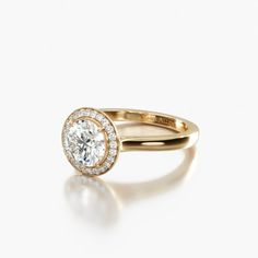 a yellow gold ring with an oval cut diamond in the center