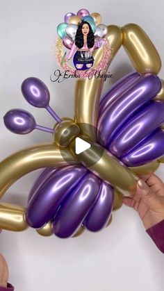 the balloon is shaped like a butterfly and has two hands holding it with one hand