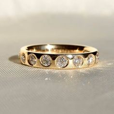 a gold ring with five diamonds on it