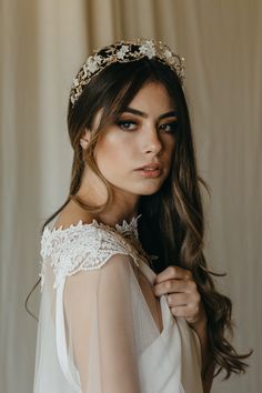 a woman with long hair wearing a white dress and a gold headpiece on her head