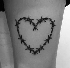 a heart shaped barbed wire tattoo on the leg