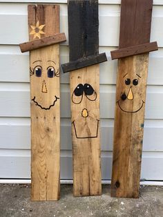 three wooden boards with faces painted on them