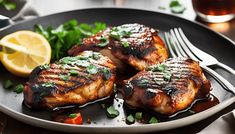 three pieces of chicken on a plate with garnishes and lemon wedges