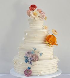 a multi layer cake with flowers on top