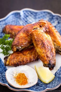 fried chicken wings with an egg on a blue and white plate