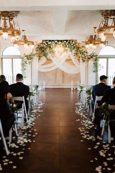 the ceremony room is decorated with white flowers and greenery