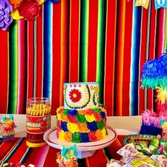 there is a colorful cake and candy bar set up on the table for a birthday party