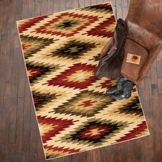 a brown chair sitting on top of a wooden floor next to a red and yellow rug