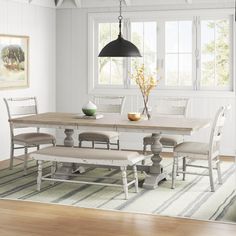 a dining room table with four chairs and a bench