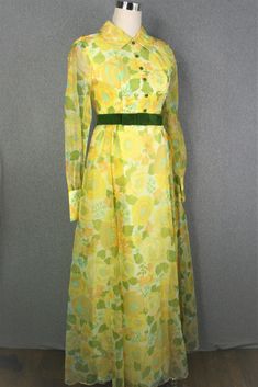 "Pretty!  This dress is of a yellow floral organza with and olive green ribbon at the empire waist and buttons.  It shows no sign of ever having been worn.   No holes stains , or tears.  Estimated size 4/6 34\" bust 28\" waist full hip 56\" nape to hem  Purveyor's Note: We have searched far and wide, wrestled bears, braved the cold, traversed mountain ranges, fought pirates, swam with sharks and eaten at many a questionable road side taco stand to provide our customers with one of a kind vintage pieces.  Know that whichever piece you choose to make your own has its own story and has traveled through time to get to you.  Though we strive to provide the absolute best, \"pristine\" vintage pieces are rare birds, if not altogether non-existent.  That being said, please understand that part of Yellow Retro Dress For Formal Occasions, Yellow Retro Formal Dress, Vintage Yellow Formal Dress, Taco Stand, Mountain Ranges, Formal Party Dress, Green Ribbon, Formal Party, Vintage Pieces