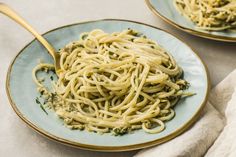 two plates filled with pasta on top of a table