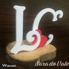 a wooden slice with the letter j on it and a red heart in the middle