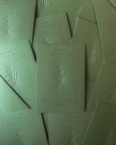 many green cards are stacked on top of each other in order to be used as wedding stationery