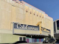 cars parked in front of a building with the name california theatre on it's side