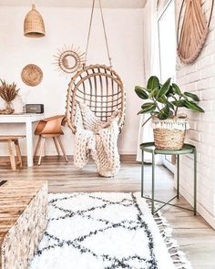 a living room filled with lots of furniture and hanging plants on the wall next to a window