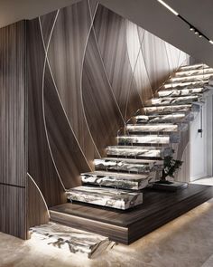 an elegant staircase with marble steps and wood paneling on the wall, leading up to the second floor