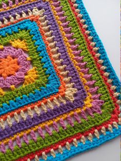 a crocheted square is shown in multicolors