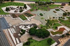 an aerial view of a parking lot with lots of grass and trees on the ground