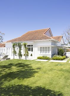 a white house sitting on top of a lush green field