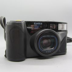 an old camera with its flash drive attached to the front and side, sitting on a white surface