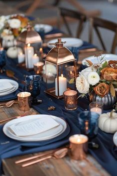 a table set with candles, plates and vases for an elegant fall wedding reception