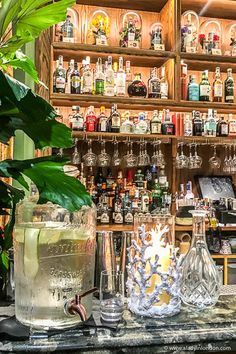 the bar has many different types of liquors on display behind glassware and bottles