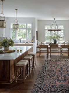 a large rug in the middle of a kitchen with lots of counter space and chairs