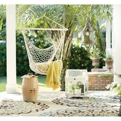 a hammock hanging from the ceiling in front of a patio with potted plants