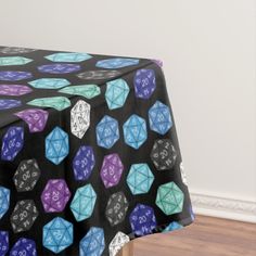 a black table cloth with blue, purple and green dices printed on the top