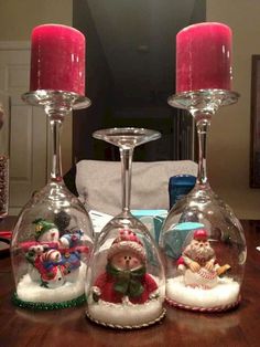 three wine glasses sitting on top of a table covered in snowmen and santa clause decorations