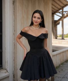 a woman in a short black dress posing for the camera with her hands on her hips