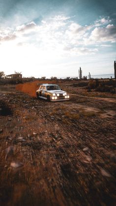 a white car driving down a dirt road