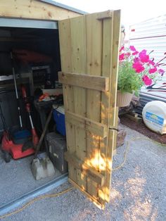 an open garage door with tools in it and flowers growing out of the back ground