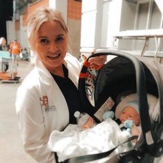 a woman holding a baby in a stroller