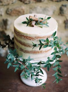 a wedding cake with greenery on top