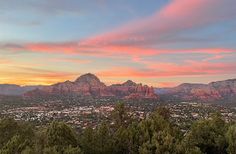 the sun is setting over the mountains in sedona, arizona as seen from an overlook