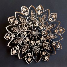 an intricate metal brooch with white and black beads in the shape of a flower