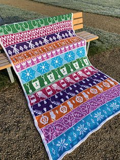 a colorful blanket sitting on top of a wooden bench