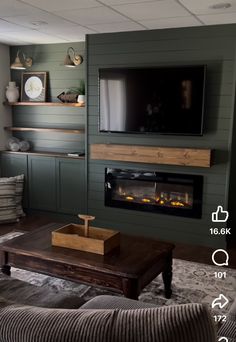 a living room with green walls and fireplace