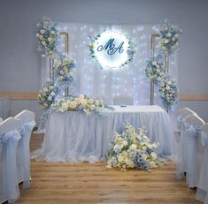 the table is set up with blue and white flowers on it for an elegant wedding