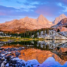 the mountains are reflected in the still water