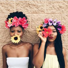 two women with flower crowns on their heads and one is holding flowers in front of her face