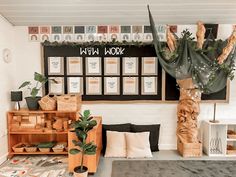 a living room filled with lots of furniture next to a wall covered in posters and plants